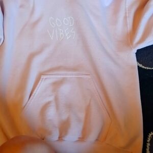 A hoodie that says good vibes on the front in light pink it's a women's and SCW